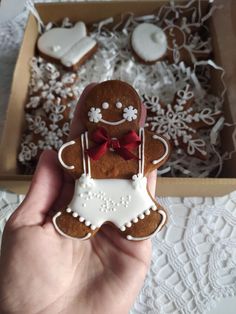 a person holding up a gingerbread decorated with icing