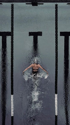 the woman is swimming in the water with her back to the camera