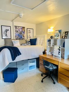 a bedroom with a bed, desk and shelves on the wall next to each other