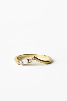 a yellow gold ring with two baguettes on the side and a diamond in the middle