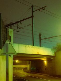 an overpass at night with street lights and power lines in the sky above it