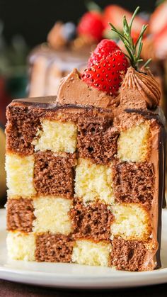 a piece of cake with chocolate frosting and a strawberry on top is sitting on a plate