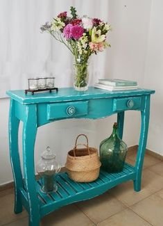 a blue table with flowers on it next to a basket