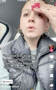 a woman sitting in the back seat of a car holding her hand up to her head