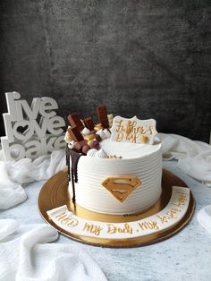 a birthday cake decorated with chocolates and candies on a table in front of a backdrop