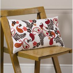 a wooden chair with a decorative pillow on it