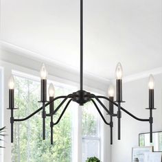 a black chandelier with five lights hanging from it's center point in a dining room