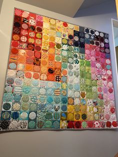 a multicolored quilt hanging on the wall