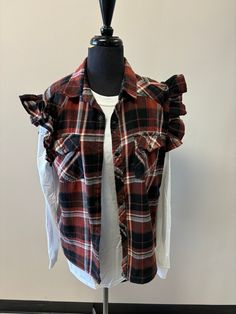 a mannequin wearing a red and black plaid shirt with ruffles on it