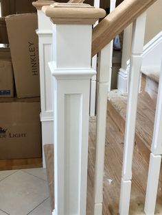 a white banister with wooden handrails and tile flooring in the background