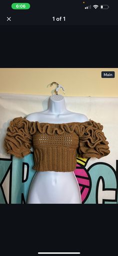 an off the shoulder crop top with ruffles on it, sitting on a mannequin