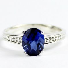 Stone Type Created Blue Sapphire Approximate Stone Size 9x7mm Approximate Stone Weight 2.3 ct Jewelry Metal Solid .925 Sterling Silver Approximate Metal Weight 3.2 grams Ring Size Size selectable during checkout Our Warranty A full year on workmanship Our Guarantee Totally unconditional 30 day guarantee Deep Blue Created Sapphire! This stone is what sapphires are all about. Well cut, with lots of blue sparkle, this totally clean stone would run about $4,000 if it were a natural Kachanaburi Royal Classic Sapphire Gemstones With Accent Stones, Elegant Blue Gemstones Stamped 925, Classic Blue Oval Gemstones, Oval Blue Sapphire Ring Stamped 925, Sterling Silver Sapphire Ring With Diamond Cut, Blue Sterling Silver Gemstones With Prong Setting, Blue Gemstones With Prong Setting In Sterling Silver, Blue Oval Sterling Silver Gemstones, Classic Blue Gemstones With Accent Stones