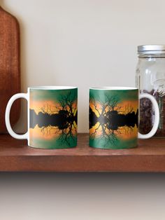 two coffee mugs sitting next to each other on a wooden shelf near a jar