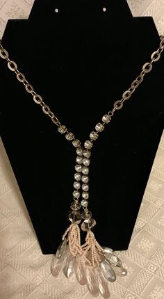 Vintage rhinestone lariat/ Y style necklace in asymetric design with beaded tassels. Closed in the middle woth 3 attached rhinestones. Silvertone chain chain into rhonestones is 21 inches long. Tassel pendant is about 6.5 inches long (see photos). Preowned. Long Tassel Necklace For Party, Silver Tassel Necklace For Party, Crystal Necklaces With Dangling Beads For Party, Adjustable Dangle Lariat Necklace For Party, Elegant Lariat Tassel Necklace For Party, Party Tassel Necklace With Adjustable Chain, Elegant Drop Necklace With Dangling Beads For Party, Long Rhinestone Necklace For Party, Silver Lariat Rhinestone Necklace For Parties