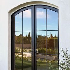 an arched glass door in front of a white building