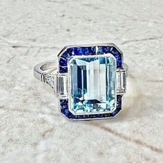 Art Deco Style Handcrafted Platinum 3.23 Carats Aquamarine, Sapphire & Diamond Halo Ring - WeilJewelry Art Deco Blue Asscher Cut Ring, Formal Blue Emerald Ring With Halo Setting, Blue Emerald Cut Ring With Vvs Clarity, Blue Diamond Asscher Cut Emerald Ring, Blue Emerald-cut Ring With Vvs Clarity, Blue Gia Certified Emerald Ring For Formal Occasions, Blue Topaz Platinum Ring With Halo Setting, Fine Jewelry Blue Rectangular Emerald Ring, Blue Emerald-cut Diamond Ring In Platinum