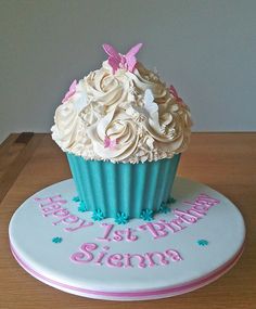 a birthday cupcake with white frosting and pink decorations