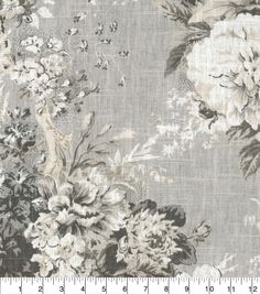 a gray and white floral print fabric with large flowers on the side, in front of a ruler