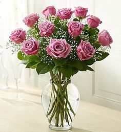 a vase filled with pink roses on top of a table