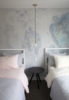 two beds in a bedroom with pink and grey bedding