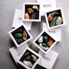 four boxes filled with rocks sitting on top of a table next to each other and the words do's written across them