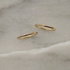 two gold rings with small diamonds on them