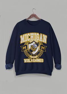 Vintage Michigan Sweatshirt, University of Michigan Crewneck, Retro Varsity Long Sleeve Sweater, Michigan University Wolverines, college football and basketball long sleeve. This is the cutest unisex sweater to wear for any occasion, but especially on game days!  ❇ Colors * Black (with yellow text) * Navy (with yellow text) * White (with blue text) * Gray (with blue text) ❇ The crewneck * 50% cotton (ethically grown in U.S.), 50% polyester * Ribbed knit collar to retain shape * Pre-shrunk * Clas Varsity Long Sleeve T-shirt For College, Collegiate Long Sleeve T-shirt For College, Collegiate Long Sleeve College T-shirt, Fan Gear Sweatshirt Long Sleeve, Fan Gear Long Sleeve Sweatshirt, Fan Apparel Long Sleeve Sweatshirt, Crew Neck T-shirt With University Logo For Fall, Collegiate Long Sleeve Graphic Sweater, Collegiate Fall Sweater For Game Day