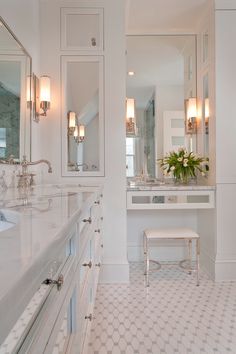 a white bathroom with two sinks and mirrors