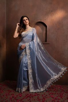 Indulge in the pure luxury of our Hand Embroidered Blue Tissue Organza Saree. Each thread is carefully and meticulously embroidered by hand, creating a one-of-a-kind piece that exudes elegance and sophistication. Elevate your style and make a statement with this exclusive saree. SKU: 0005 Luxury Tissue Silk Saree With Motifs, Luxury Chinon Saree With Chikankari Embroidery, Elegant Tissue Silk Blouse With Floral Embroidery, Blue Tissue Silk Saree For Reception, Luxury Embroidered Festive Traditional Wear, Blue Blouse Piece In Tissue Silk With Traditional Drape, Blue Tissue Silk Traditional Wear For Party, Blue Traditional Wear With Sheer Dupatta In Tissue Silk, Elegant Blue Blouse Piece With Intricate Embroidery