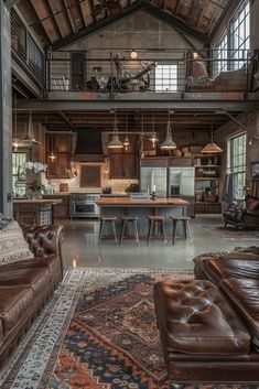 a living room filled with furniture next to a kitchen and dining area in a loft