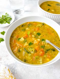 two white bowls filled with soup on top of a table