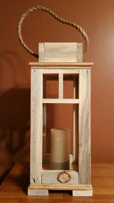 a small wooden lantern with a rope hanging from it