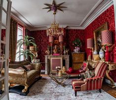 a living room filled with lots of furniture and red wall coverings on the walls