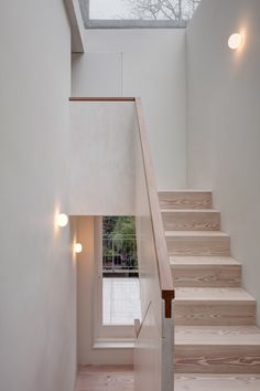 the stairs are made of wood and have white walls