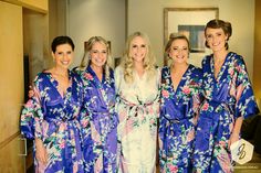 the bride and her four bridesmaids pose for a photo in their matching robes