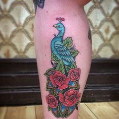 a woman's leg with flowers and a blue bird on top of the legs