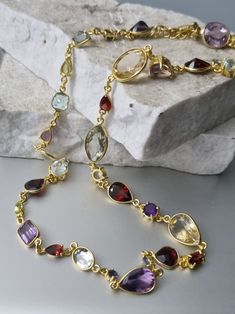 A sublime collection of gemstones forms this gorgeous piece. All set in 14k gold vermeil, on top of 925 silver. NO BRASS There are a total of 34 stones in Amethysts, Citrines, Garnets, Blue Topaz, Tanzanites. All in varying sizes and varying cuts. The largest measures 15mm x 8mm, smallest 5mm. Length of necklace is 18 inches with a further 3/4" of extension chain. Luxury Amethyst Multi-stone Necklace, Luxury Multi-stone Amethyst Necklace, Oval Amethyst Multi-stone Necklaces, Amethyst Oval Multi-stone Necklace, Oval Amethyst Multi-stone Necklace, Formal Multi-stone Amethyst Necklaces, Formal Amethyst Multi-stone Necklace, Formal Multi-stone Amethyst Necklace, Multi-stone Amethyst Necklace For Anniversary