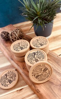 four wooden coasters sitting on top of a table next to a potted plant