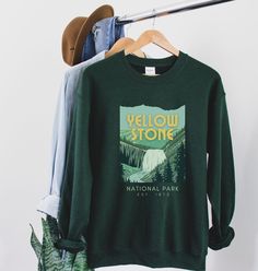 *PLEASE ask any questions about holiday shipping dates prior to purchase:) YELLOWSTONE Sweatshirt featuring Gibbon Falls | Yellowstone Shirt A cozy way to commemorate your Yelllowstone adventure! Printed on a classic unisex Gildan cotton sweatshirt. Colors: Forest Green *50% Cotton 50% Polyester *Medium-heavy fabric * Loose fit *Runs pretty true to size, slightly larger ♥♥SIZING♥♥ ♥Modern Unisex Fit. Women may want to size down if you prefer a more fitted look. Men may want to size up if you wan Yellowstone Tshirt, Yellowstone Sweatshirt, Cat Christmas Sweater, Sweatshirt Colors, National Park Shirt, Yellowstone Park, Retro Gift, Cat Sweatshirt, Gildan Sweatshirts