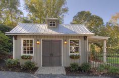 a small house with a metal roof and two windows on the front door is shown