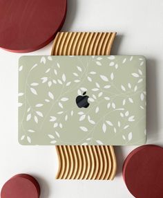 an apple computer sitting on top of a table next to gold plates and red circles