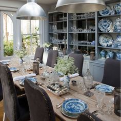 the dining room table is set with blue and white china