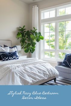 a white bed sitting under a window next to a green plant in a vase on top of a dresser