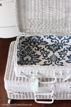 a white wicker trunk with blue and white fabric