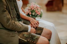 a man and woman sitting next to each other holding hands