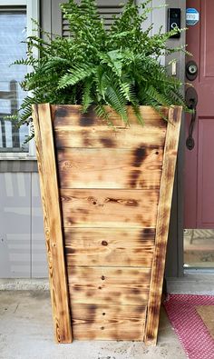 a wooden planter with green plants in it