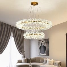 a living room filled with furniture and a chandelier hanging from the middle of it