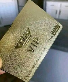 a person holding up a gold credit card