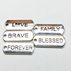 three metal tags that say love, brave, and forever