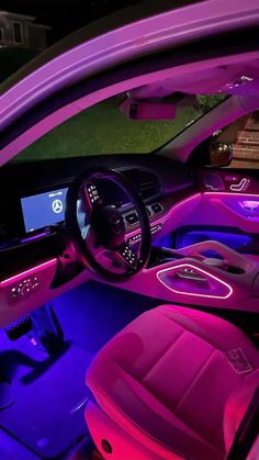 the interior of a car is lit up with purple lights